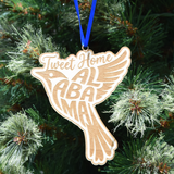 Tweet Home Alabama wooden bird ornament featuring laser-engraved lettering, natural wood finish, and hanging ribbon for Christmas tree décor and Alabama gifts. (Ribbon Color May Vary)