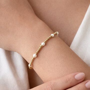 Gold and pearl beaded bracelet close-up showing polished gold beads and white pearls