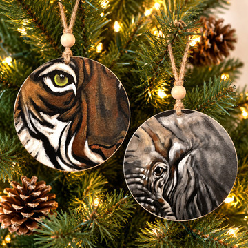 Eye of the Tiger OR Eye of the Elephant ornaments, each with detailed animal artwork, wooden Alabama-made hanging ornaments featuring rustic jute cords and nature-inspired design.