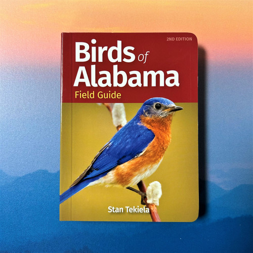 Birds of Alabama Field Guide open book showing color-organized bird photos and species identification layout