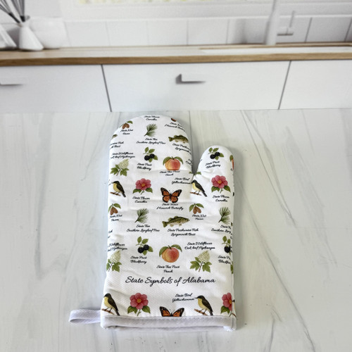 Alabama state symbols oven mitt with yellowhammer bird and camellia flower design hanging in a Southern kitchen
