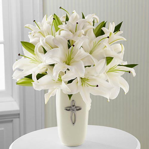 White Lilies in a white ceramic vase with a cross