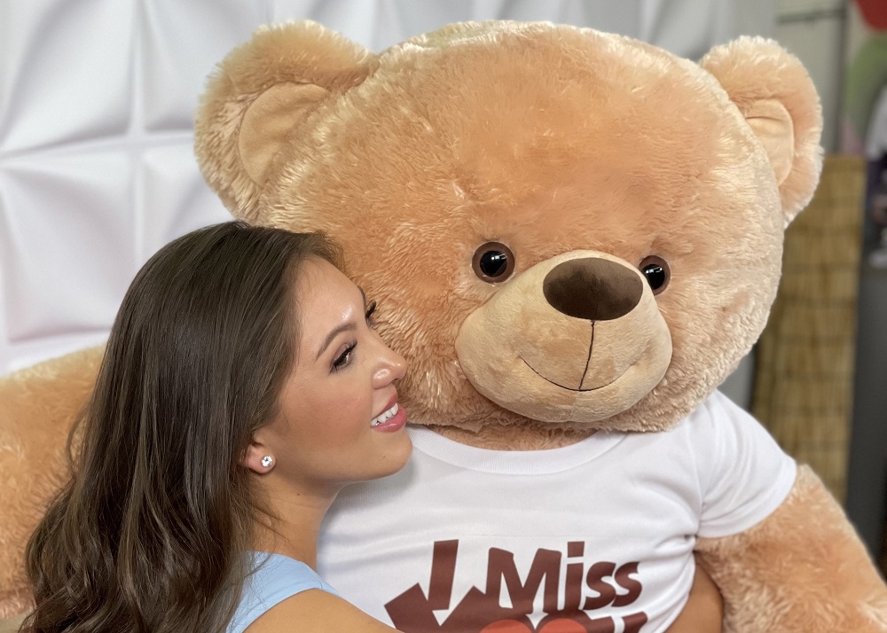 A Woman Hugging a Giant Teddy Bear That Says Miss You