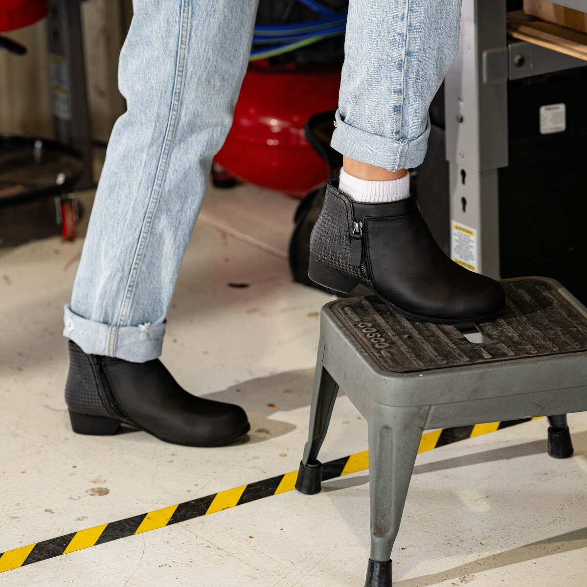 rk751-carlywork-rockportworks-4-square.jpg Woman stepping onto a stool wearing Carly Work RK751 women's work shoes.