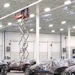 Scissor lift raised toward a warehouse roof deck