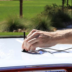 Magnet-mount antenna being installed on a car roof