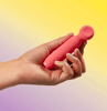 Je Joue VITA Clitoral Stimulator held in hand to show scale, highlighting the curved ergonomic shape, rounded stimulation head, and compact handheld design.