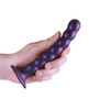 Beaded Metallic Purple Silicone Dildo held in hand showing flexible 6.5-inch size