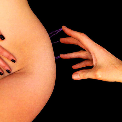 Close-up of fingertip electro play showing visible electrical arc between hand and skin using Kinklab Power Tripper attachment