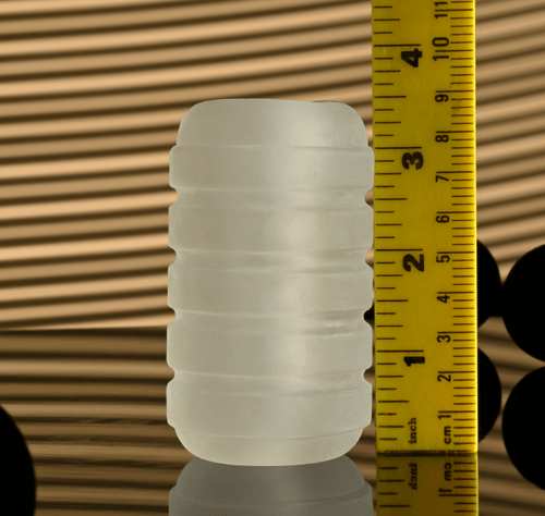 Clear ribbed male stroker standing upright beside a measuring ruler to demonstrate its compact 3.7-inch length
