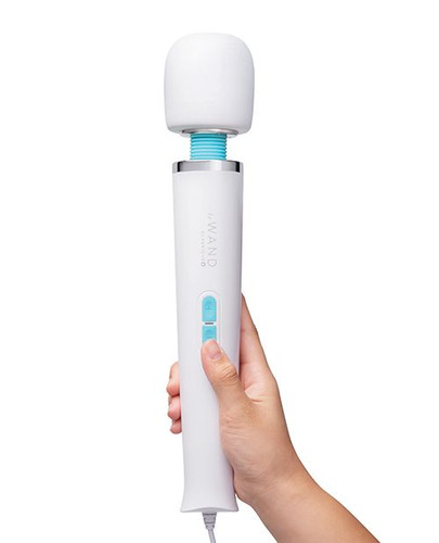 Le Wand Classique Plug-In Wand Massager held in hand, featuring a soft silicone head, sleek white handle, and easy vibration controls.