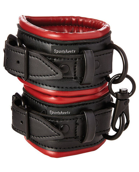 Close-up of soft-lined vegan leather wrist cuffs with stitching detail and nickel-free D-ring attachment for bondage play