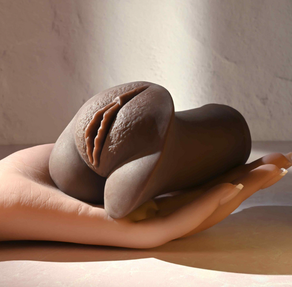 Selopa Pocket Pleaser stroker sleeve held in hand with realistic lips design and dark skin tone finish