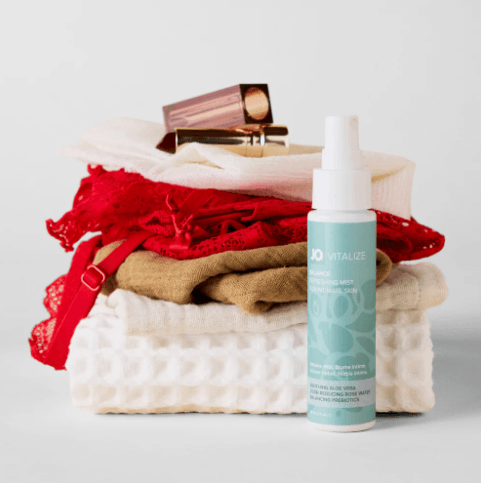JO Vitalize Balance Refreshing Intimate Mist bottle shown with bathroom towels