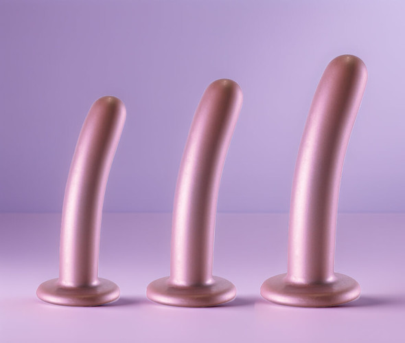 Smooth As Silk Rose Gold Silicone Dildos in Small, Medium and Large sizes on a soft lavender background