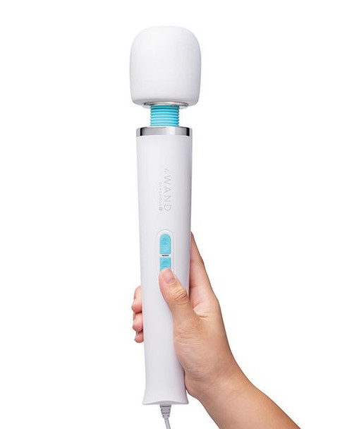 Le Wand Classique Plug-In Wand Massager held in hand, featuring a soft silicone head, sleek white handle, and easy vibration controls.