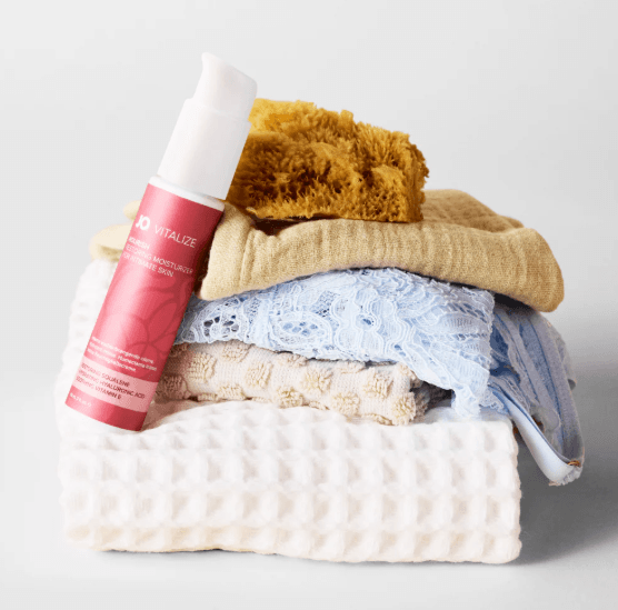 JO Vitalize Nourish Restoring Intimate Moisturizer product image showing the pink and white pump bottle layed over stack of bathroom towels