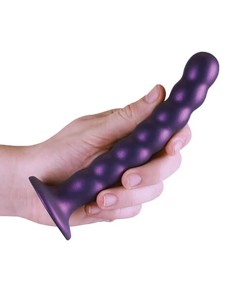 Beaded Metallic Purple Silicone Dildo held in hand showing flexible 6.5-inch size