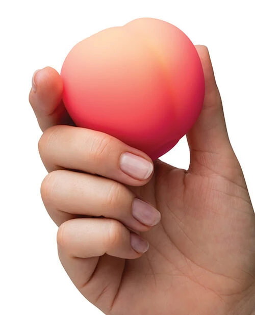ROMP peach clitoral stimulator, held in hand