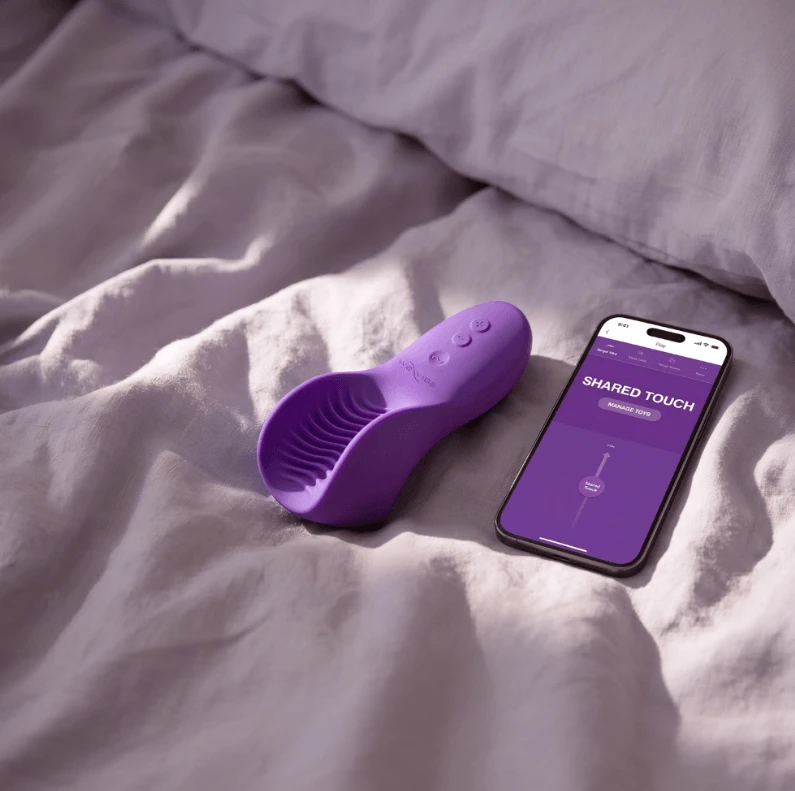 We-Vibe Shared Touch shown on bed with connected phone
