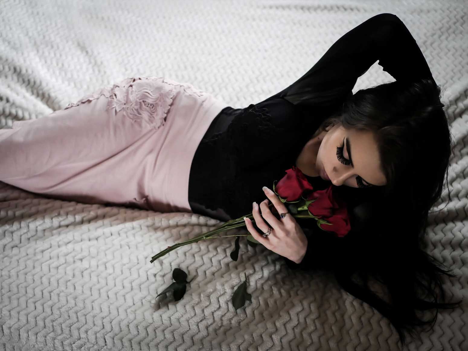 woman in a bed holding roses