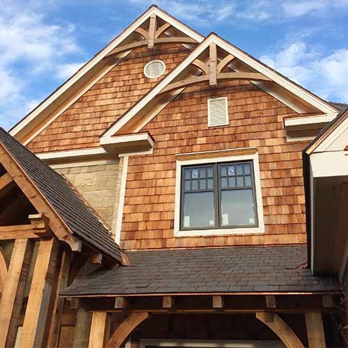 Large, decorative timber brackets are installed in the peaks of the gables.