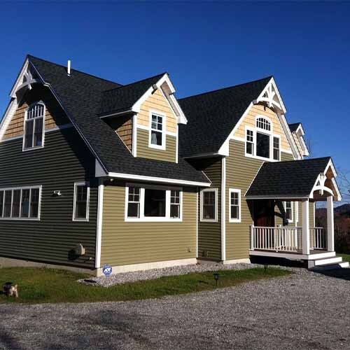 Craftsman New England style home featuring prominent gable brackets