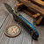 Microtech LUDT Ram-Lok Manual Flamed Grooved Titanium 3.4" Clip Point Stonewash M390MK Blue Ti Accent Marfione Select 1135RLG-10MS4
