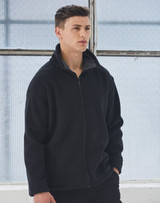 A black polar fleece jacket with a zip and high collar, worn by a male model in a bright, industrial setting.