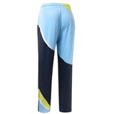 Track pants in light blue, navy, and lime green featuring a bold geometric design and an elastic waistband.