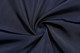 A dark navy fabric with a smooth texture, arranged in a spiral pattern, showcasing its soft feel.