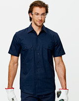 A navy cotton drill short sleeve work shirt with two chest pockets, worn by a model wearing safety glasses and gloves.