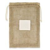 A jute net produce bag with a drawstring closure and a white label patch in the center.