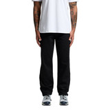 Black relaxed pants worn by a person standing, paired with a plain white t-shirt and athletic shoes.