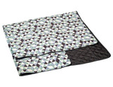 A large picnic rug featuring a geometric pattern in shades of green, blue, and black, with a quilted black underside.