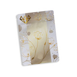 A small, metallic stand-up pouch in silver and gold, featuring floral designs and a logo.