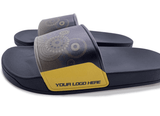A pair of navy blue slippers with a patterned strap and a space for a logo on the side.