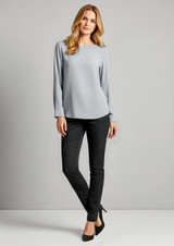 A model wearing grey top and black leggings stands against a plain background. The leggings have a sleek design and a logo.