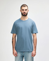 A light blue midweight t-shirt worn by a male model, featuring a simple design and a logo.