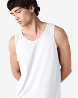 A white Gildan Heavy Cotton adult tank top on a model, showcasing the simple design and relaxed fit.
