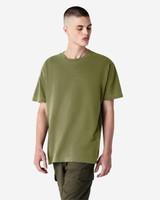 A model wearing an olive green unisex heavyweight cotton T-shirt. The shirt has a relaxed fit and short sleeves.