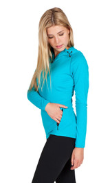 A woman wearing a turquoise half-hood top with long sleeves and a zippered pocket. The top features a logo.