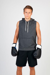 A sleeveless grey hoodie is worn by a male model, paired with black boxing gloves and shorts against a plain background.