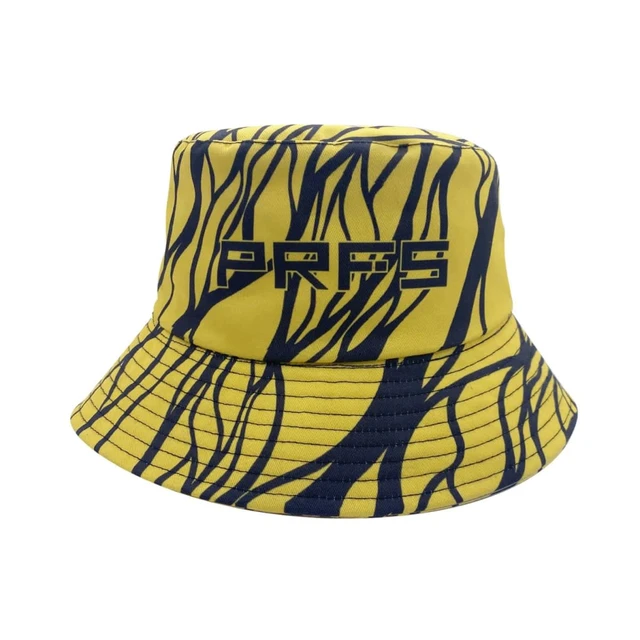 A reversible bucket hat featuring a yellow and navy abstract design, with a logo on the front.