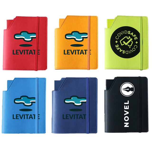 A collection of six leatherette notebooks in various colours: orange, green, blue, and black, each with a logo.