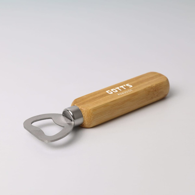 A bamboo bottle opener with a stainless steel opening end and a smooth wooden handle, featuring a logo.