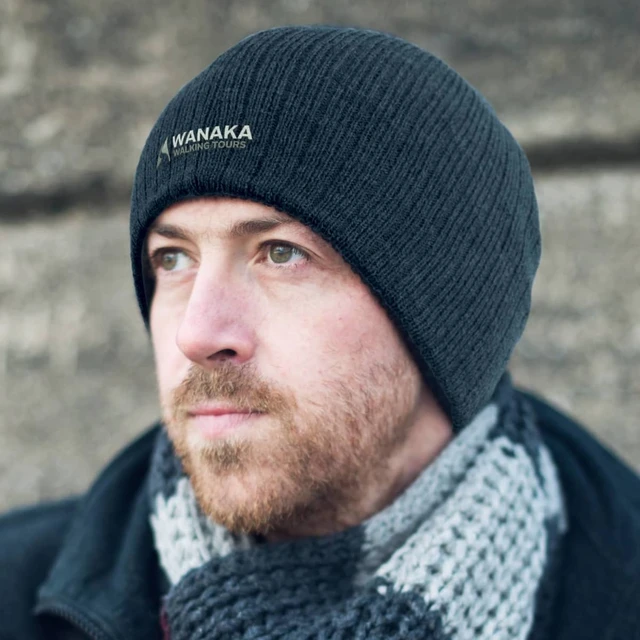 A Nebraska Cable Knit Beanie in black, featuring a subtle logo and a textured knit design.