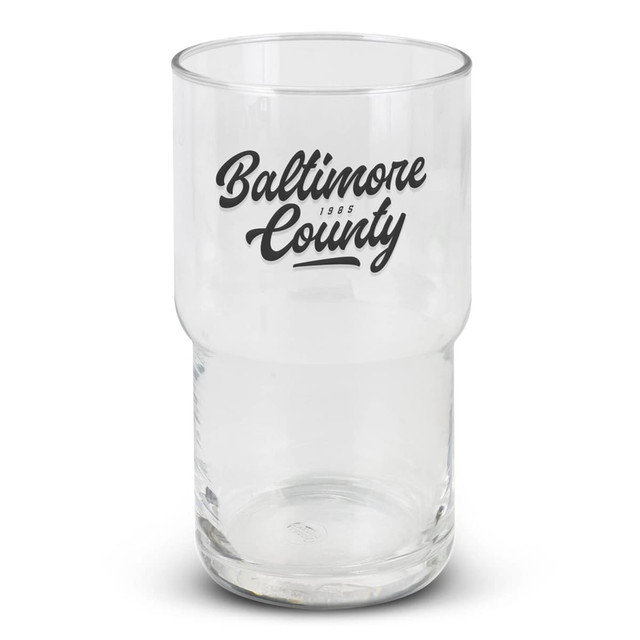 A clear stackable glass tumbler featuring a black logo. The glass has a cylindrical shape with a wider base.