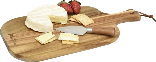 A wooden cheese board featuring a wedge of brie cheese, crackers, strawberries, and a stainless steel cheese knife.