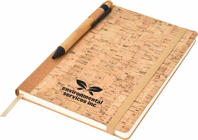 A cork-covered A5 notebook with an elastic band and a pen, featuring a logo on the front.